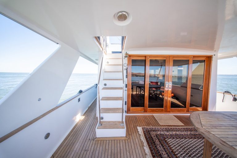 Alexander 56 teak aft deck with stairs to the flybridge and saloon doors – Convés de popa em teca do Alexander 56 com escada para o flybridge