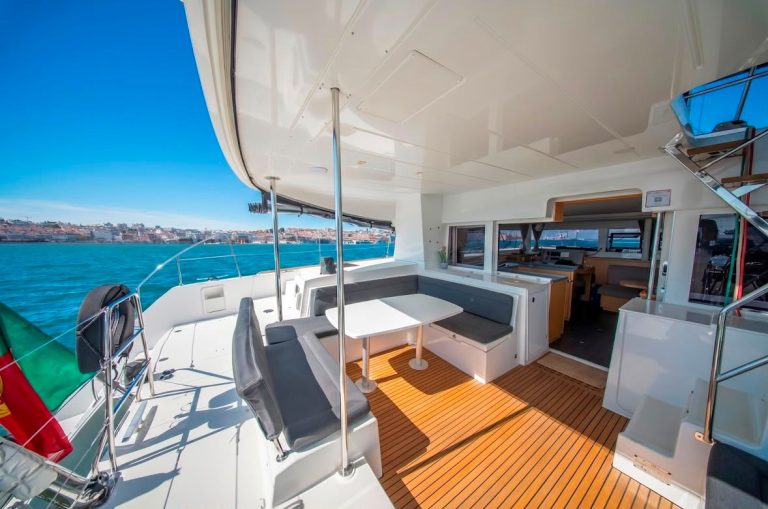 Lagoon 45 cockpit dining area and saloon with the Lisbon skyline – Zona de refeições do Lagoon 45 com vista para Lisboa