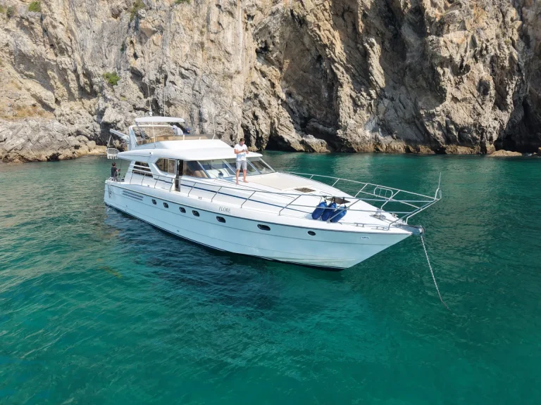 Aerial drone view of the Princess 65 yacht anchored in turquoise water below limestone cliffs – Vista aérea do iate Princess 65 ancorado em águas turquesa junto às falésias